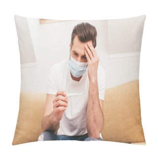 Personality  Man In Medical Mask With Hand Near Forehead Holding Thermometer On Sofa At Home  Pillow Covers