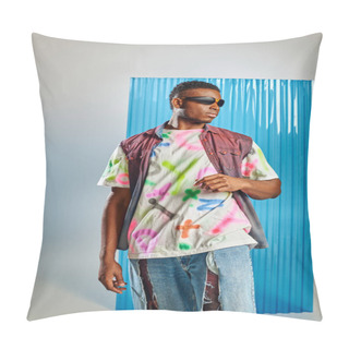 Personality  Fashionable Young Afroamerican Model In Sunglasses, Colorful Denim Vest And Ripped Jeans Standing On Grey With Blue Polycarbonate Sheet At Background, Sustainable Fashion, DIY Clothing Pillow Covers