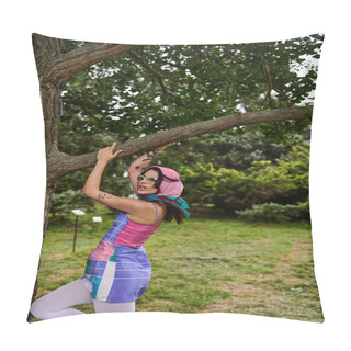 Personality  A Young Woman In A Vibrant Dress And Sunglasses Climbing Up A Tree Branch, Embracing The Summer Breeze In Nature. Pillow Covers
