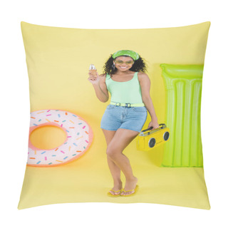 Personality  Full Length Of Happy African American Young Woman Standing With Boombox And Ice Cream Cone Near Inflatable Ring And Mattress On Yellow Pillow Covers