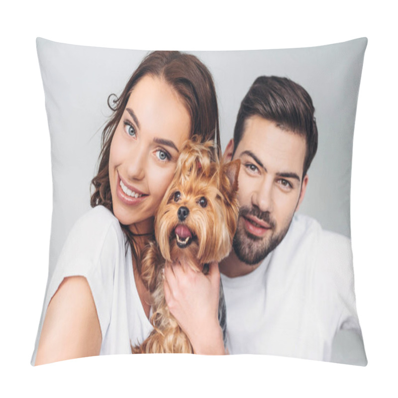 Personality  portrait of young smiling couple with yorkshire terrier looking at camera isolated on grey pillow covers