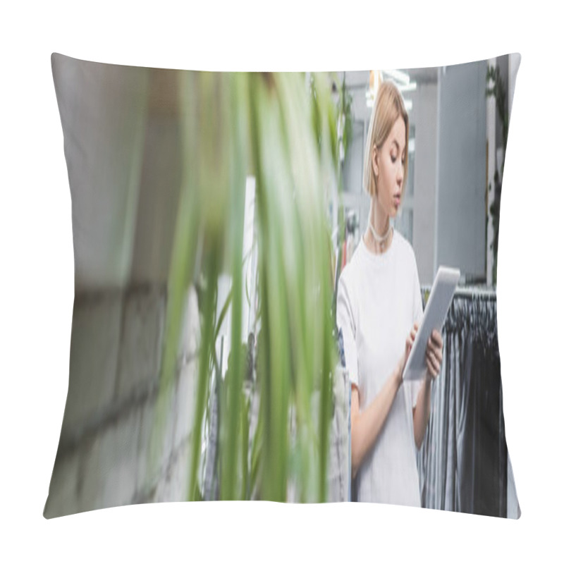Personality  Young saleswoman using digital tablet near blurred clothes in second hand, banner  pillow covers