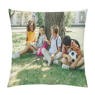 Personality  Four Cute Multicultural Schoolkids Talking While Sitting On Lawn Under Tree Pillow Covers