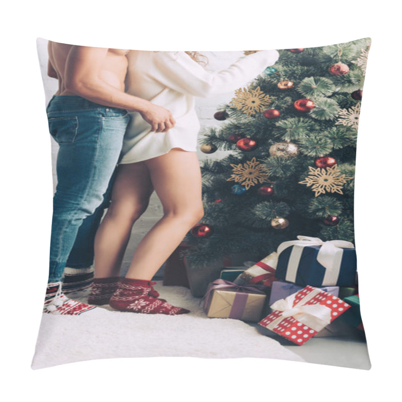 Personality  cropped image of shirtless muscular man embracing girlfriend near decorated christmas tree at home pillow covers