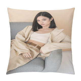 Personality  Sensual Asian Woman In Stylish Pantsuit Sitting In Armchair And Looking At Camera On Beige Background Pillow Covers