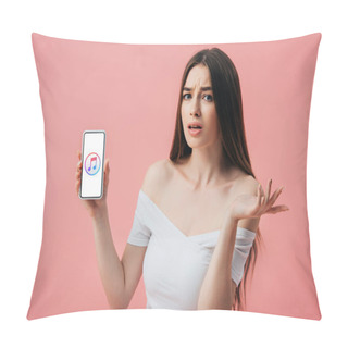 Personality  KYIV, UKRAINE - JUNE 6, 2019: Beautiful Confused Girl Holding Smartphone With ITunes App And Showing Shrug Gesture Isolated On Pink Pillow Covers