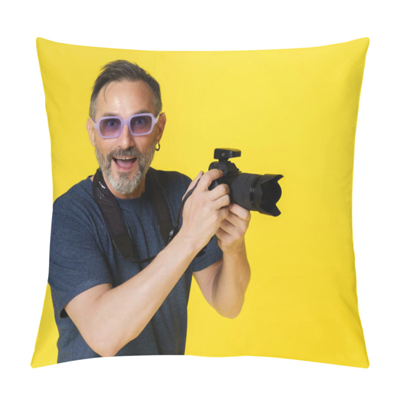 Personality  Smiling and happy mid-aged man, passionate about photography, isolated on yellow background, holding digital photo camera. Joy and contentment of mid-aged individual indulging in photography hobby pillow covers
