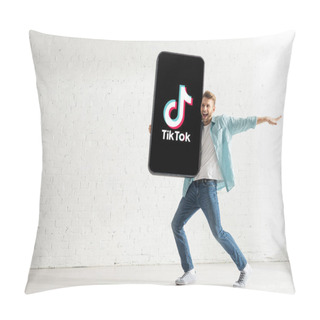 Personality  KYIV, UKRAINE - FEBRUARY 21, 2020: Handsome Man Smiling While Holding Big Model Of Smartphone With TikTok App At Home  Pillow Covers