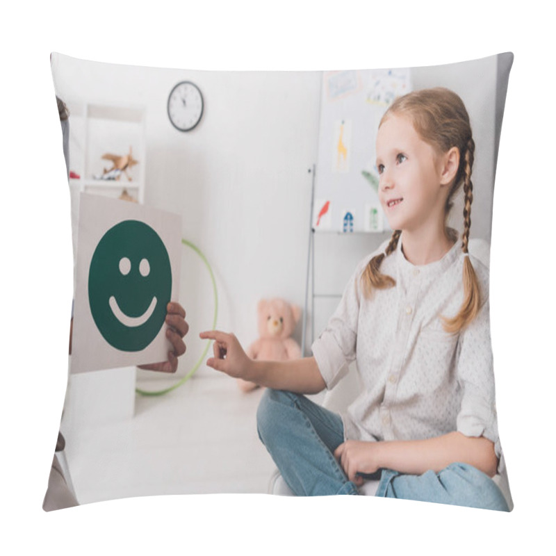 Personality  adorable little child pointing at smiley face on paper in hand of psychologist  pillow covers