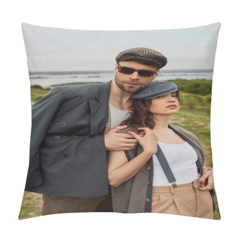 Personality  Fashionable man in sunglasses and jacket hugging brunette girlfriend in newsboy cap and suspenders while standing with blurred scenic landscape and sky at background, trendy twosome in rustic setting pillow covers
