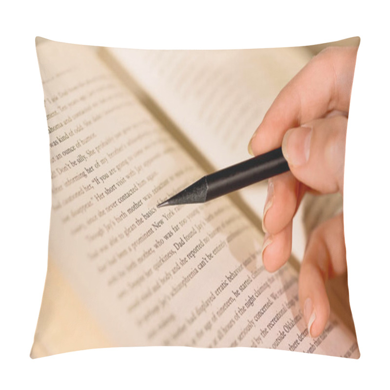 Personality  Cropped view of woman holding pencil near book  pillow covers