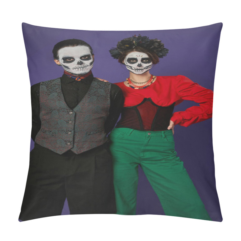 Personality  stylish couple in festive attire and dia de los muertos makeup looking at camera on blue backdrop pillow covers