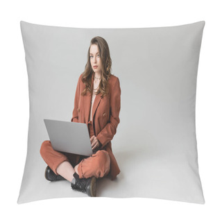 Personality  Charming Young Woman In Golden Necklace Sitting With Crossed Legs In Terracotta And Trendy Suit, Using Laptop While Working Remotely On Grey Background, Freelancer, Digital Nomad  Pillow Covers