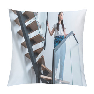 Personality  Low Angle View Of Smiling Woman In Jeans Looking Away While Standing On Stairs At Home Pillow Covers