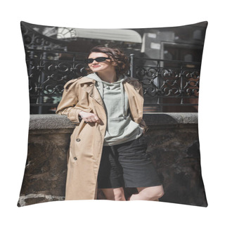 Personality  Travel Lifestyle, Trendy And Cheerful Woman In Grey Hoodie, Beige Trench Coat And Stylish Sunglasses Standing With Hand In Pocket Of Black Shorts And Looking Away Near Forged Fence On City Street Pillow Covers