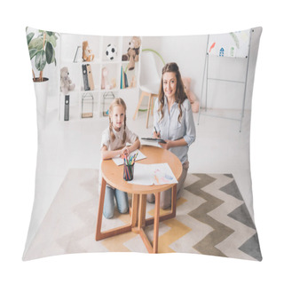 Personality  Happy Psychologist With Clipboard Sitting Near Little Child While She Drawing With Color Pencils And Looking At Camera Pillow Covers