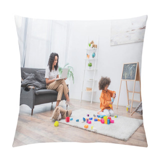 Personality  Smiling Woman Using Laptop On Couch While Daughter Playing Building Blocks At Home  Pillow Covers