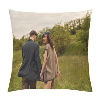 Personality  Fashionable Brunette Woman In Vest And Newsboy Cap Looking At Camera And Holding Hand Of Bearded Boyfriend And Walking With Landscape At Background, Stylish Couple In Rural Setting Pillow Covers
