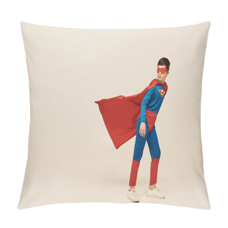 Personality  full length of courageous asian boy in superhero costume with cloak and mask looking away and standing against wind during World Child protection day on grey background  pillow covers