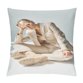 Personality  Young And Fashionable Woman In Pastel Beige Suit Sitting With Hand Near Head In Sunlight On Grey Pillow Covers