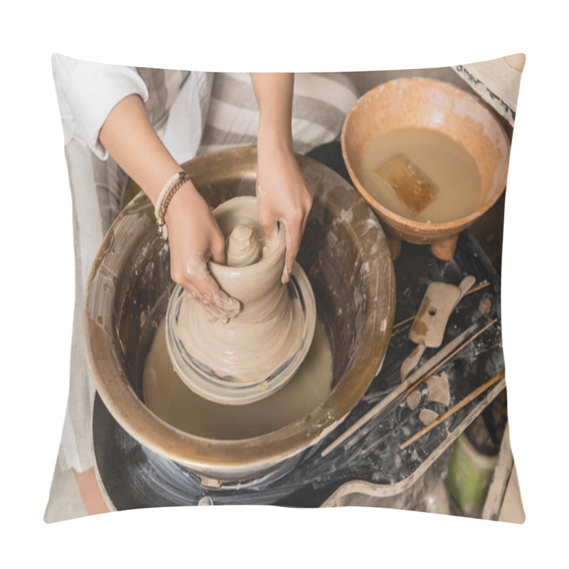 Personality  Top view of young female artisan molding wet clay on pottery wheel near tools and bowl with water in ceramic workshop, pottery studio workspace and craft concept pillow covers