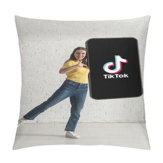 Personality  KYIV, UKRAINE - FEBRUARY 21, 2020: Beautiful Young Woman Pointing With Finger At Big Model Of Smartphone With TikTok App At Home  Pillow Covers