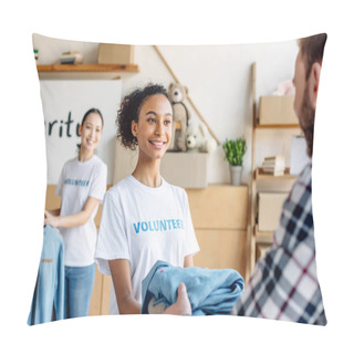Personality  Selective Focus Of Beautiful African American Volunteer Giving Clothes To Man While Asian Girl Standing Near Rack With Shirts Pillow Covers