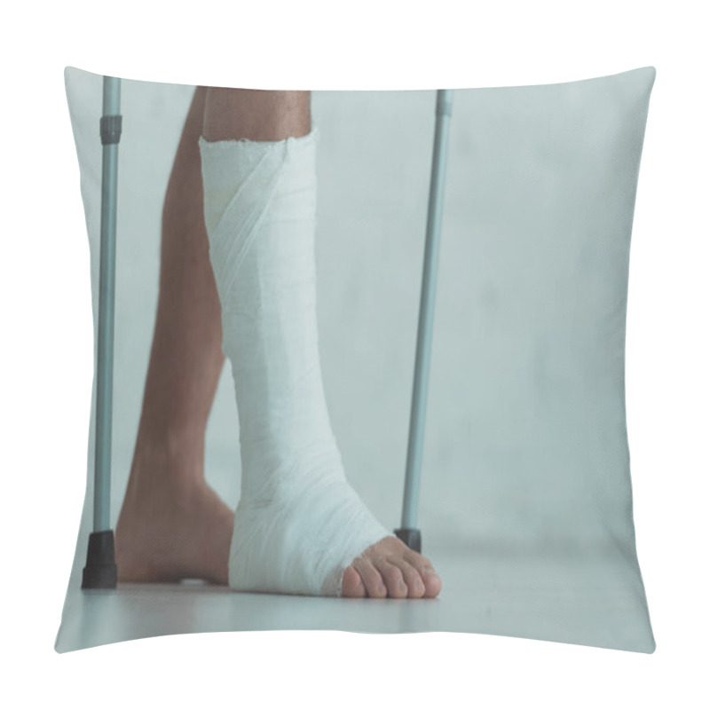 Personality  Cropped view of man with gypsum on leg holding crutches  pillow covers
