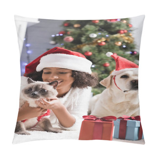 Personality  Happy African American Girl In Santa Hat Cuddling Cat While Lying On Floor Near Labrador Dog On Blurred Background Pillow Covers