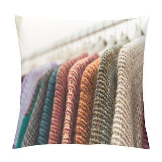 Personality  Nice Warm Colorful Sweaters Hang On Hangers Inside Of A Shopping Mall. Beautiful Clothes For Winter Autumn Season. Fashion Industry For Women And Men. Wool Things For Fall. Classic Design. Merchandise In A Shop. Pillow Covers