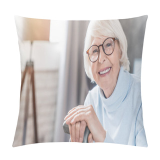 Personality  Portrait Of Happy Mature Woman In Eyeglasses Holding Cane While Sitting On Sofa At Home Pillow Covers