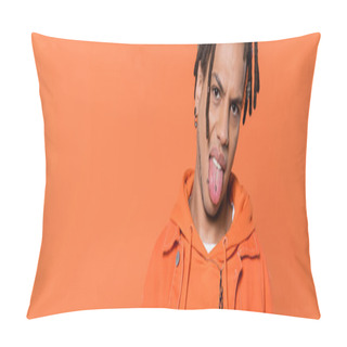 Personality  Pierced And Multiracial Man With Dreadlocks Looking At Camera While Sticking Out Tongue Isolated On Coral Background, Banner  Pillow Covers