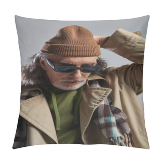 Personality  Portrait Of Senior And Bearded Man In Dark Sunglasses, Beige Trench Coat And Plaid Scarf Adjusting Beanie Hat On Grey Background, Hipster Style, Fashionable Aging Concept Pillow Covers