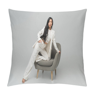 Personality  Full Length Of Young Asian Woman Leaning On Armchair While Posing With Hand In Pocket On Grey Pillow Covers