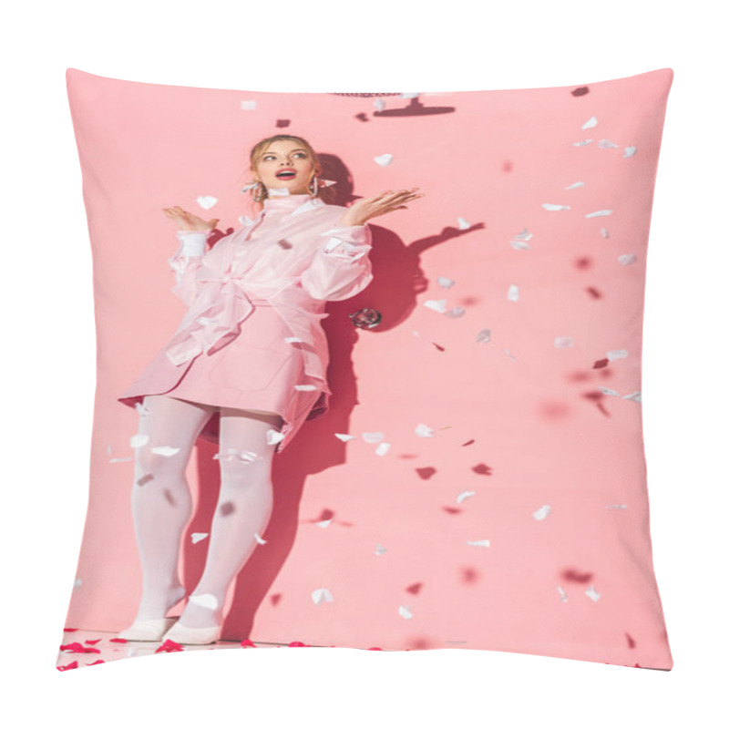 Personality   attractive surprised young woman standing near rose petals on pink pillow covers