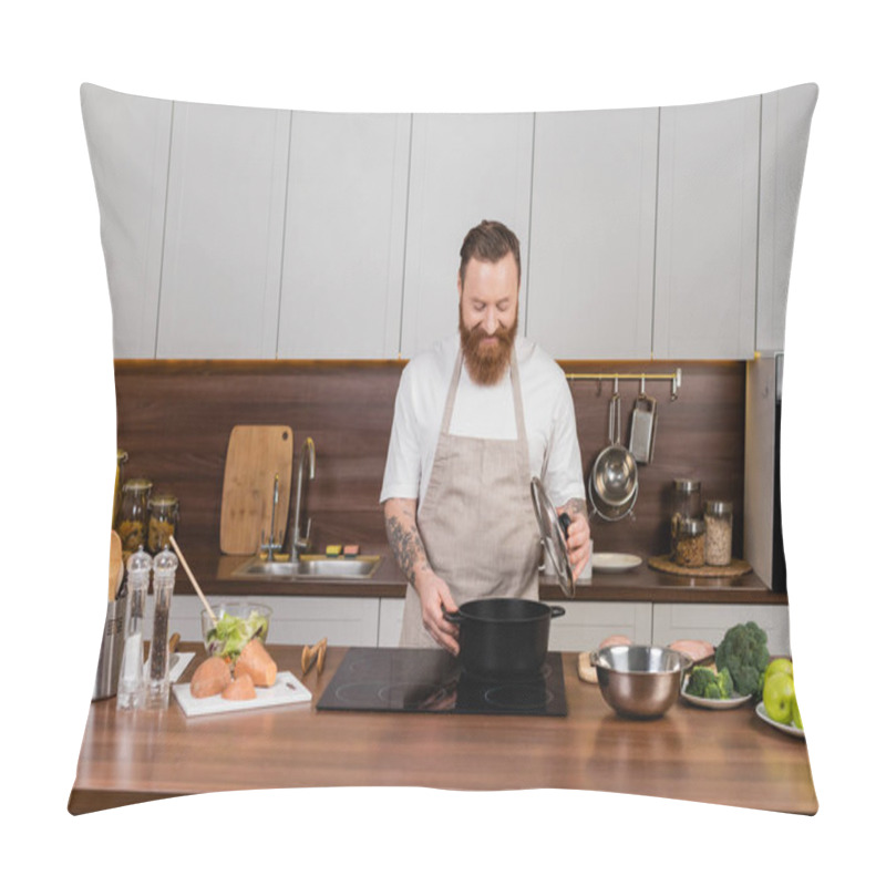 Personality  Tattooed man looking at pot on stove while cooking in kitchen  pillow covers