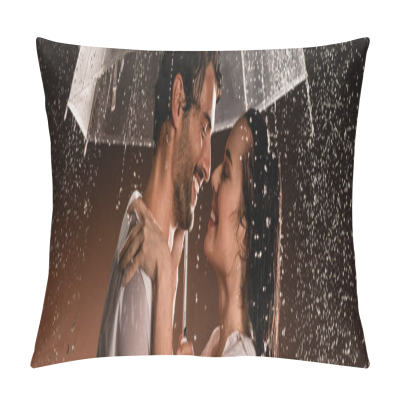 Personality  side view of happy couple in wet shirts standing face to face under rain with transparent umbrella on dark background, banner pillow covers