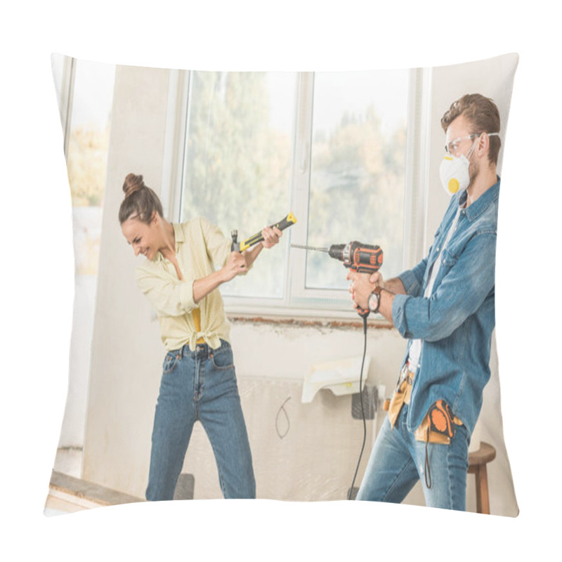 Personality  happy young couple having fun with tools during repairment in new apartment pillow covers