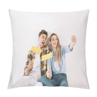 Personality  Cheerful Young Couple Taking Selfie While Sitting Near White Wall And Holding Yellow Paint Rollers Pillow Covers