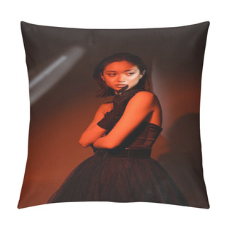 Personality  Stunning Asian Woman With Short Hair And Wet Hairstyle Posing In Strapless Dress And Glove With Trendy Cuff Earring And Necklaces On Dark Orange Background With Red Lighting, Young Model, Looking Away Pillow Covers