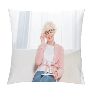 Personality  Portrait Of Smiling Senior Woman In Eyeglasses With Tablet In Hands Resting On Sofa And Looking At Camera At Home Pillow Covers