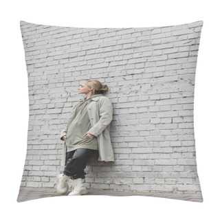 Personality  Young Woman With Makeup, Blonde Hair, Bangs, In Stylish Outfit With Long Hoodie, Coat, Black Leather Pants And Beige Boots Standing With Closed Eyes Near Grey Brick Wall Of Modern Building  Pillow Covers