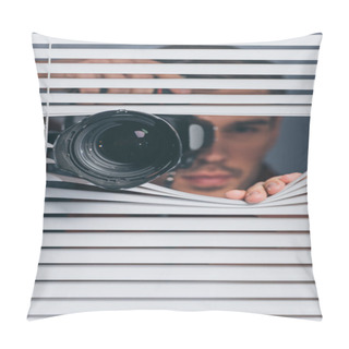 Personality  Close-up View Of Young Man Holding Camera And Looking At Camera Through Blinds Pillow Covers