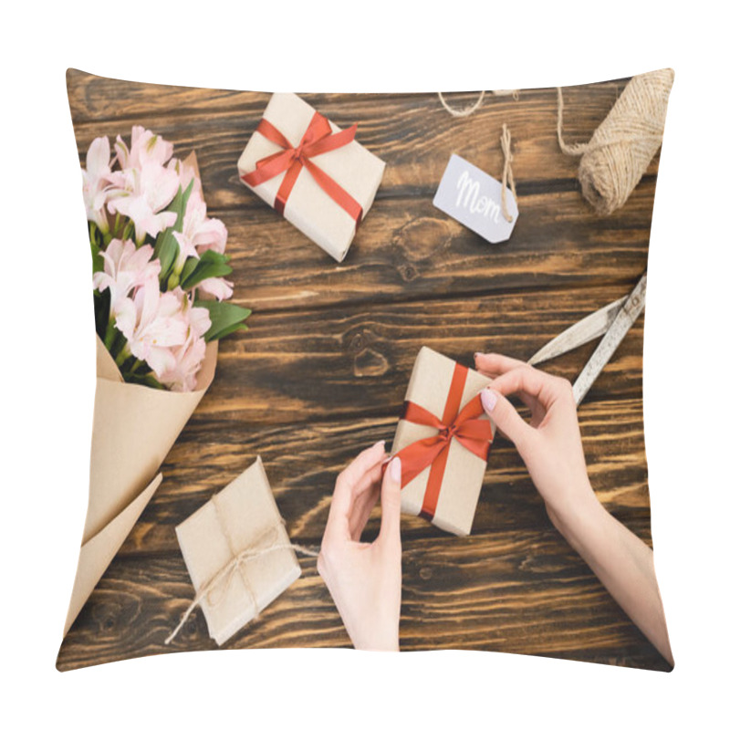Personality  cropped view of woman touching ribbon on present near pink flowers wrapped in paper and tag with mom lettering, mothers day concept  pillow covers