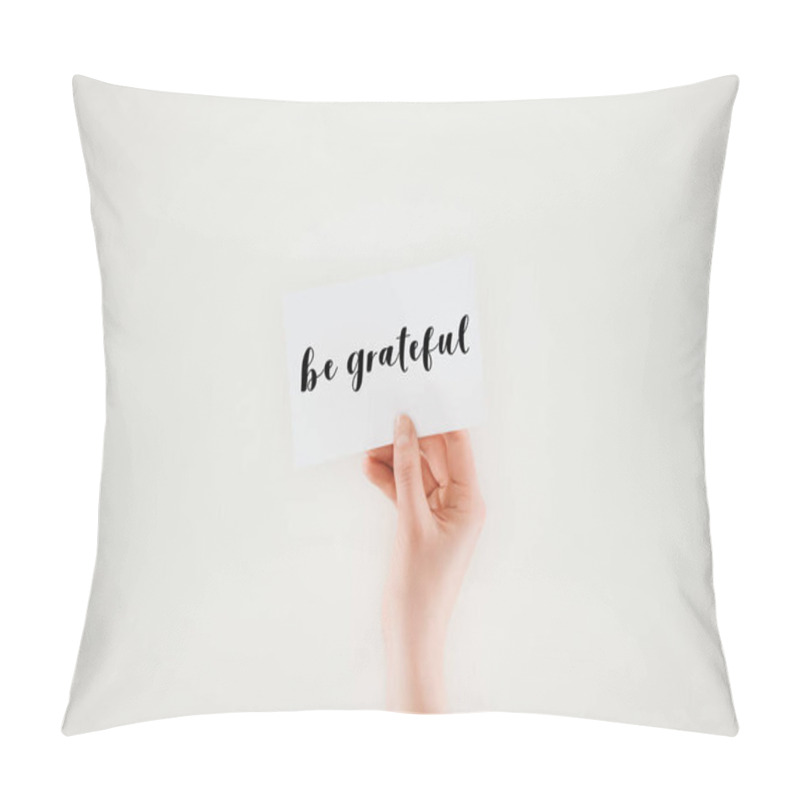 Personality  cropped shot of woman holding paper with be grateful lettering isolated on white pillow covers