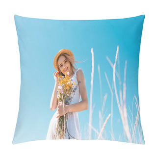 Personality  Selective Focus Of Woman In White Dress Touching Hair While Holding Wildflowers And Looking At Camera, Low Angle View Pillow Covers
