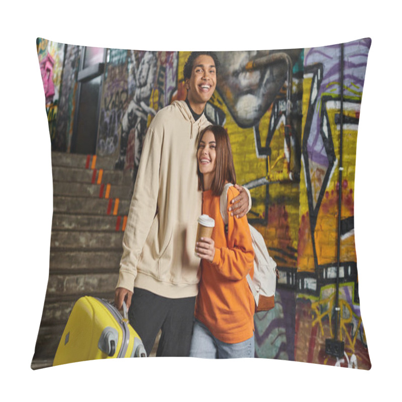 Personality  happy diverse couple embracing by a staircase with graffiti on background, black man with luggage pillow covers