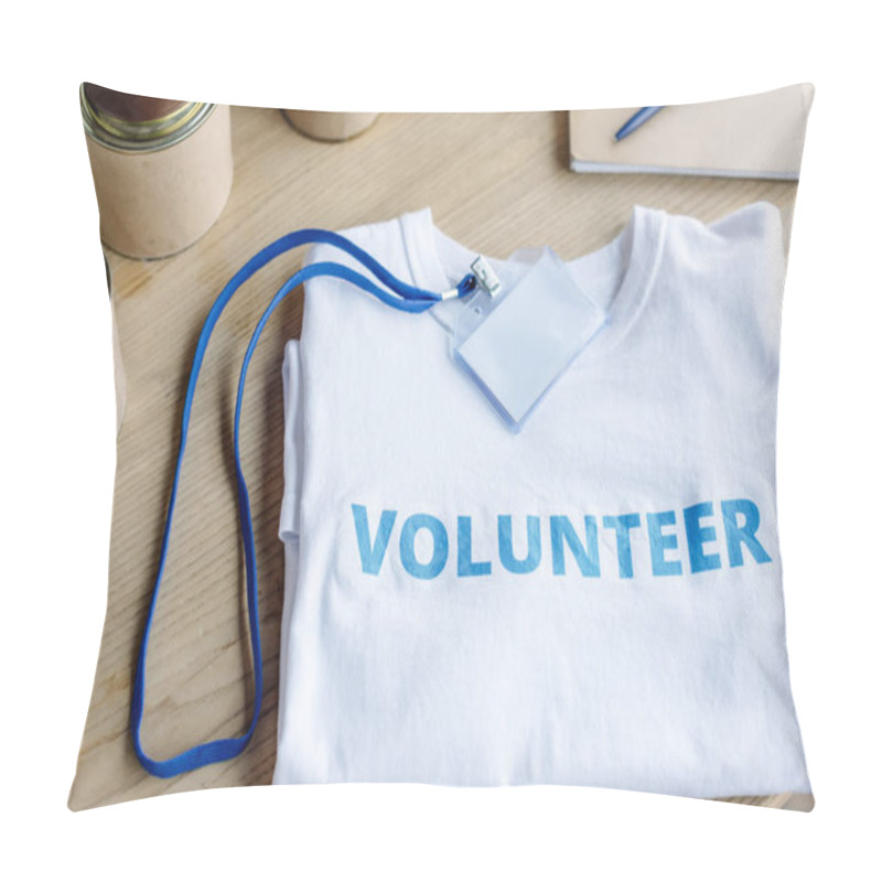 Personality  White T-shirt With Blue Volunteer Inscription, Badge And Tins On Wooden Table Pillow Covers