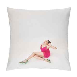 Personality  Playful Girl In Pink Dress And Green Shoes Touching Her Ear And Sitting On Grey Background Pillow Covers