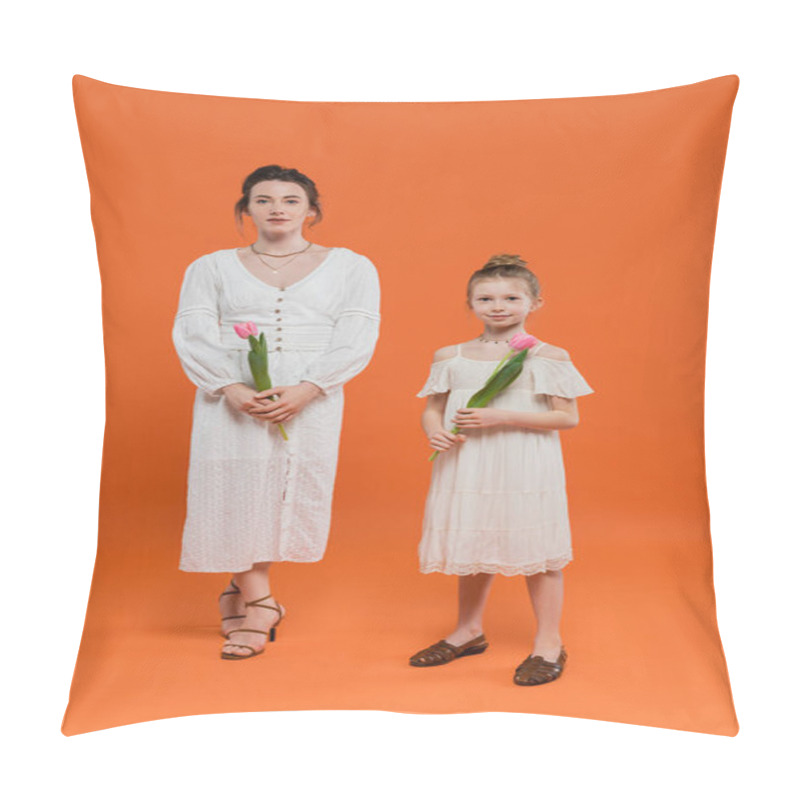 Personality  happy mother and daughter with tulips, young woman and girl holding flowers and standing on orange background, family style, joyful occasion, fashion and nature pillow covers